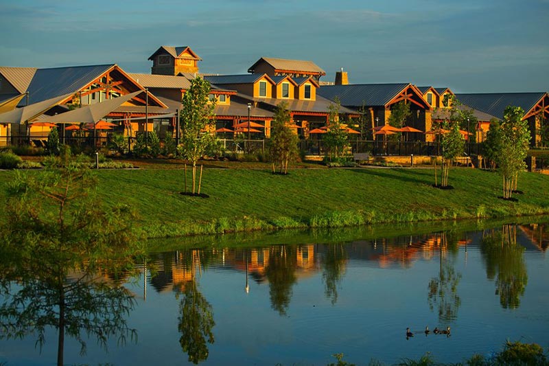 View of the expansive clubhouse at Del Webb Sweetgrass at sunset.