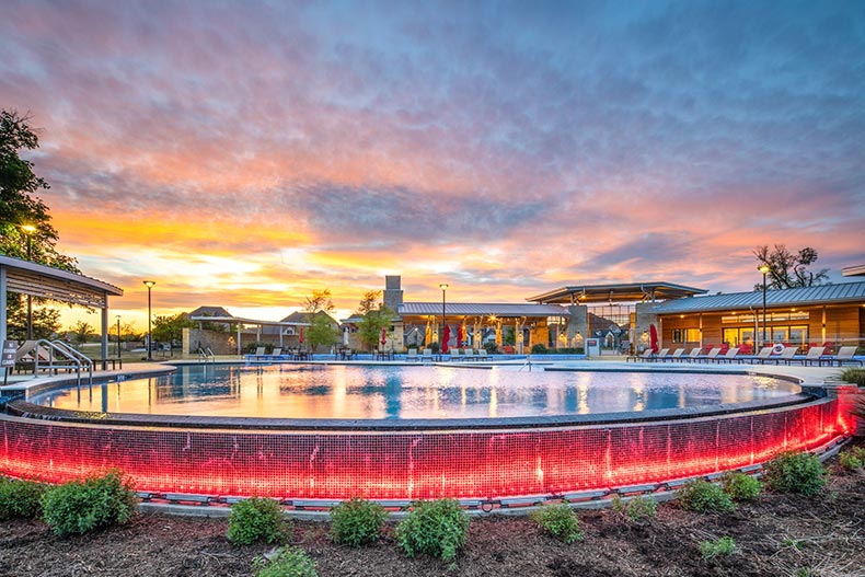 Sunset view of the outdoor pool at Del Webb Trinity Falls in McKinney, Texas