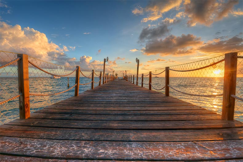 Ocean waters behind a wooden pier with railings