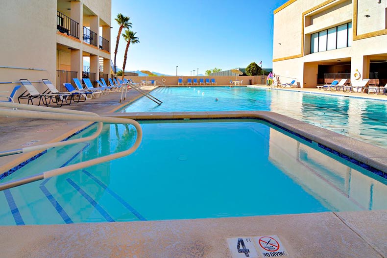 Lounge chairs surrounding the outdoor pool at Desert Hills 3 West in Green Valley, Arizona