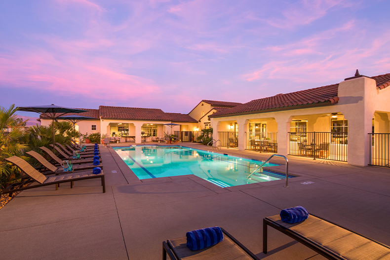 View of a resort-style pool and patio outside of the clubhouse at Domani, located in Palm Desert, California