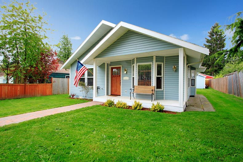 A small home with a porch and a front yard