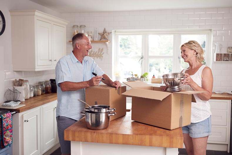A senior couple packing and labelling moving boxes