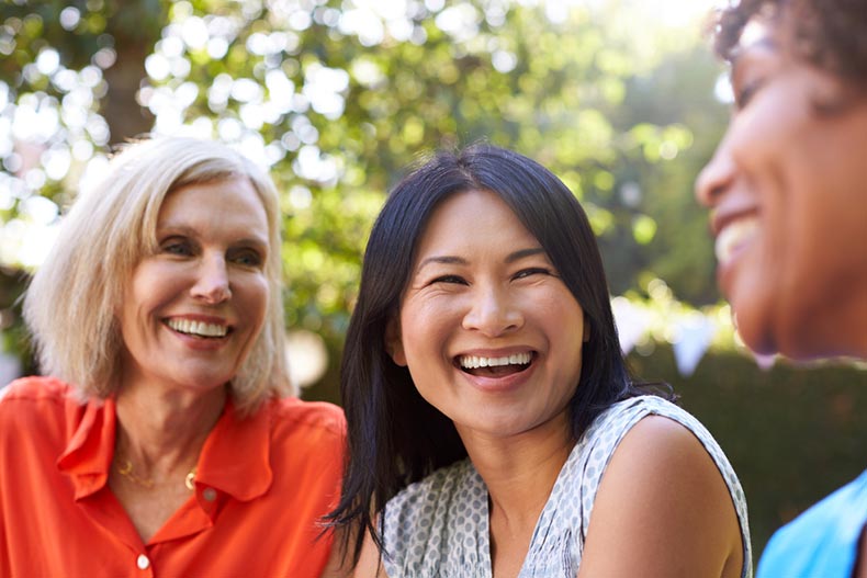 Mature female friends socializing in a backyard together