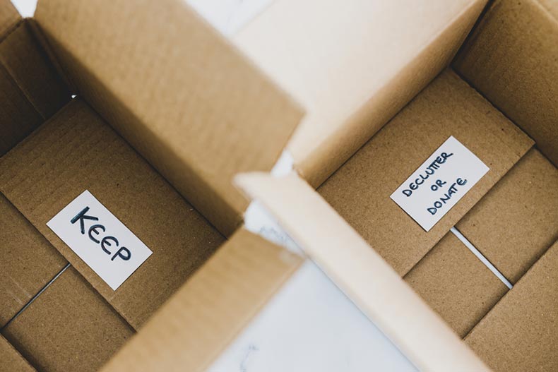 Two open cardboard boxes; one marked "Keep" and the other marked "Declutter or Donate"