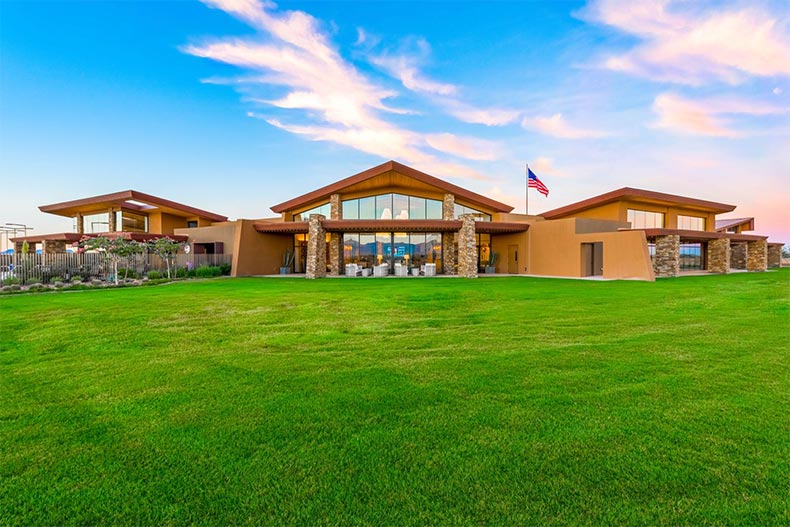 Exterior view of the community clubhouse on a green lawn at Encore at Eastmark in Mesa, Arizona