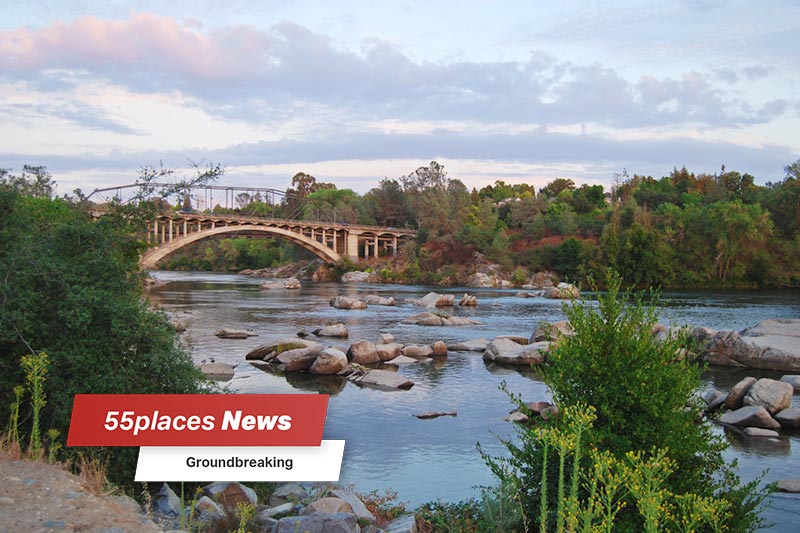 Rainbow Bridge in Folsom, California in the early morning with green trees along the river banks