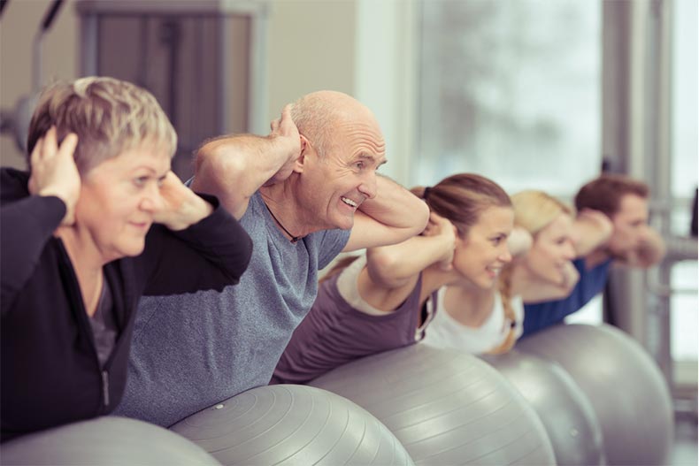 Young and older people exercising in a pilates class at the gym