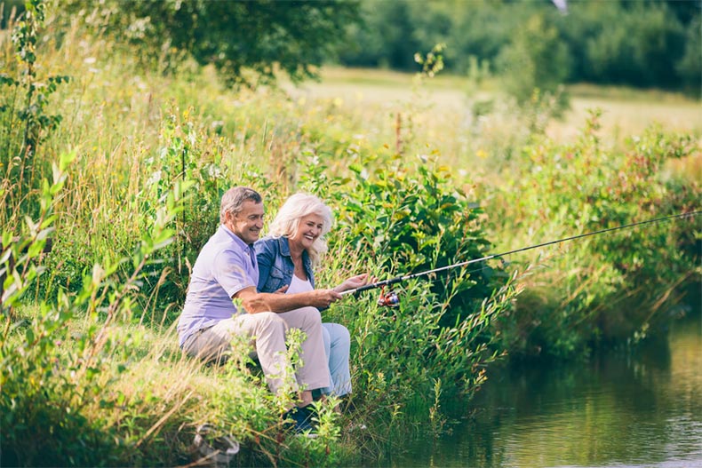 A senior couple fishing on the banks of a river