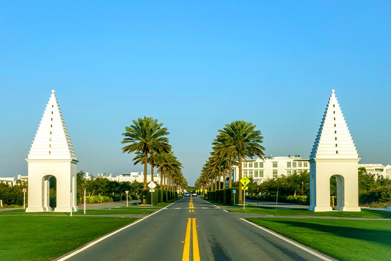 Perspective shot of East County High 30A surrounded by two white steeples and multiple palm trees in Alys Beach, Florida