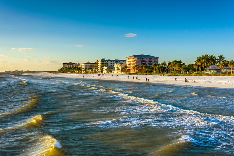 View of a Fort Myers, Florida beach and buildings from over the waves, with some beachgoers on the shore