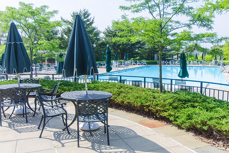 Tables and chairs surrounding the outdoor pool at Four Seasons at Lakewood in Lakewood, New Jersey