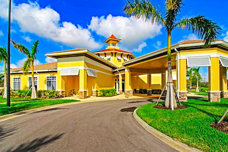 Exterior of the bright yellow clubhouse at Cascades at River Hall.