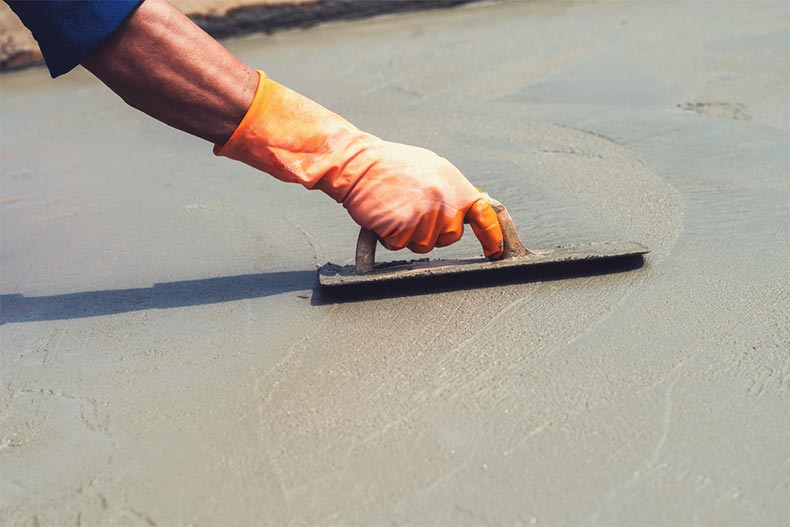 Closeup on a hand leveling concrete at a construction site