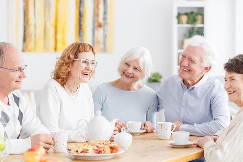 A club of happy older people meeting over tea and pastries