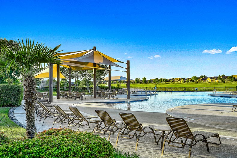 Lounge chairs on the patio beside the resort-style pool at Frisco Lakes in Frisco, Texas
