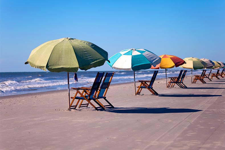 Sun chairs and umbrellas lined up on a beach in Galveston, Texas