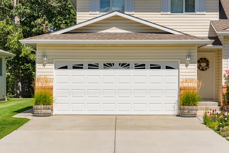 A closed garage door attached to a quaint house