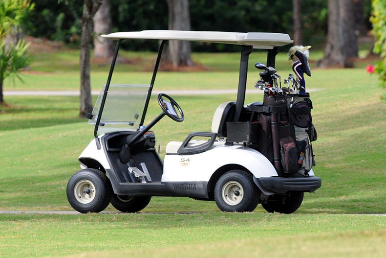 A golf cart loaded with clubs on a fairway