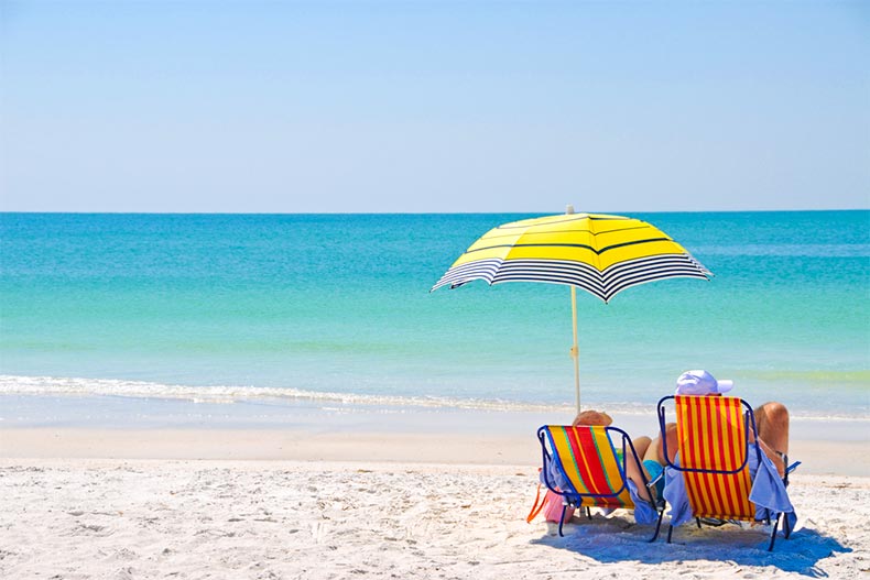 A couple lounging on a Florida Gulf Coast beach on a clear day
