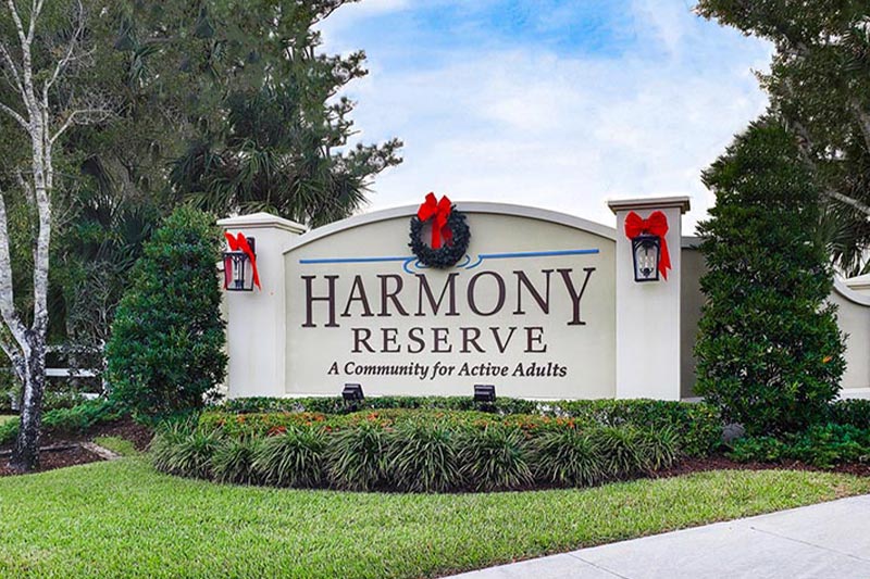 View of the entrance sign at Harmony Reserve with Christmas wreaths decorating it.