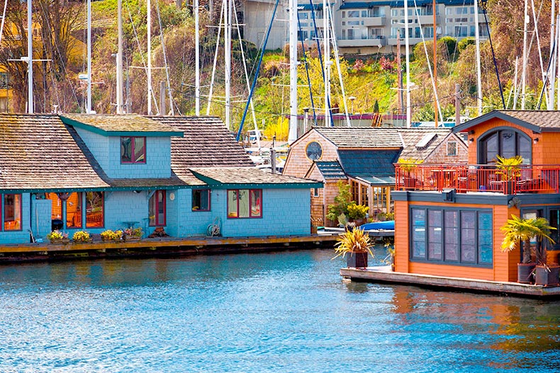 A marina of colorful houses boats floating on blue water