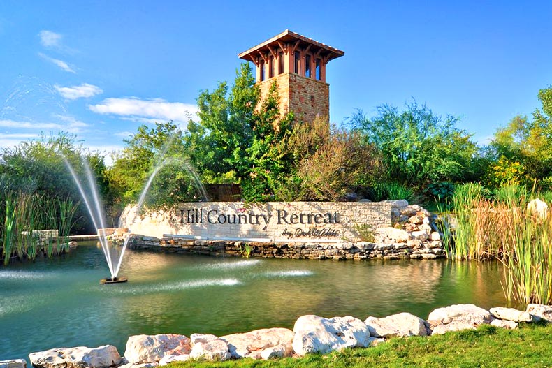 Photo of the Hill Country Retreat entrance sign with a pond and fountain in front