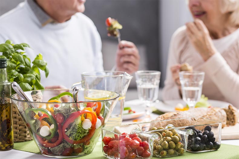 A senior couple enjoying a meal of fresh, healthy foods