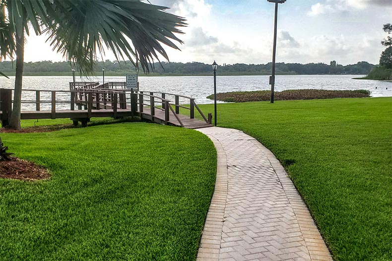 A walkway beside the water at Villas of Lake Arbor in Clearwater, Florida