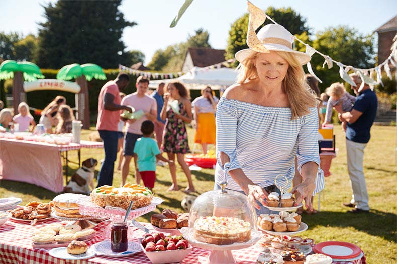 A senior woman organizing an outdoor picnic for a fundraising event