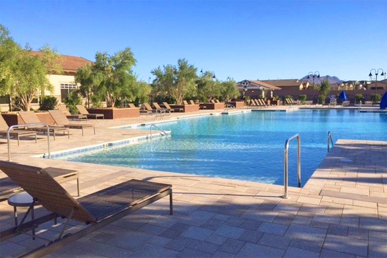 Lounge chairs on the patio beside the outdoor pool at Heritage at Cadence in Henderson, Nevada