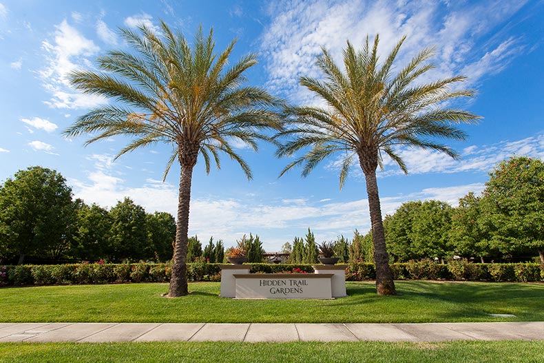 Palm trees beside the sign for the Hidden Trail Gardens at Heritage Park in Sacramento, California