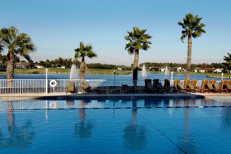 View of the outdoor pool and patio overlooking the pond at Heritage Springs in Trinity, Fl.