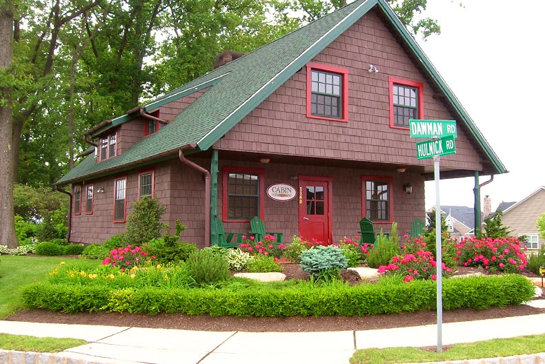 Exterior view of The Cabin with a garden and street sign out front located in The Villages at Hillview in Coatesville, Pennsylvania