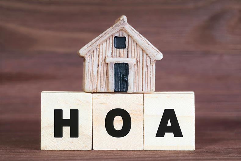 "HOA" made from wooden letter blocks with a miniature house on top
