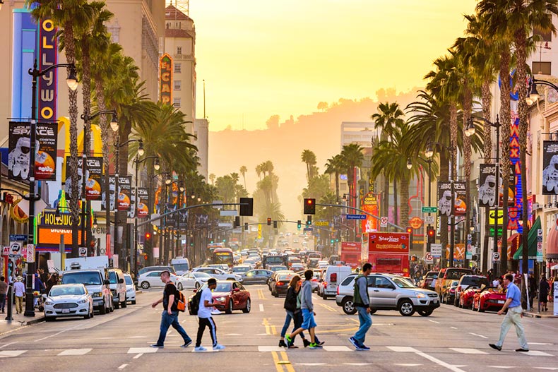 Traffic and pedestrians on Hollywood Boulevard at dusk in Los Angeles, California