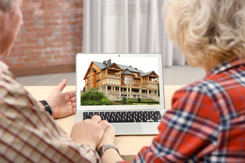 A senior couple looking for a house on a real estate market website