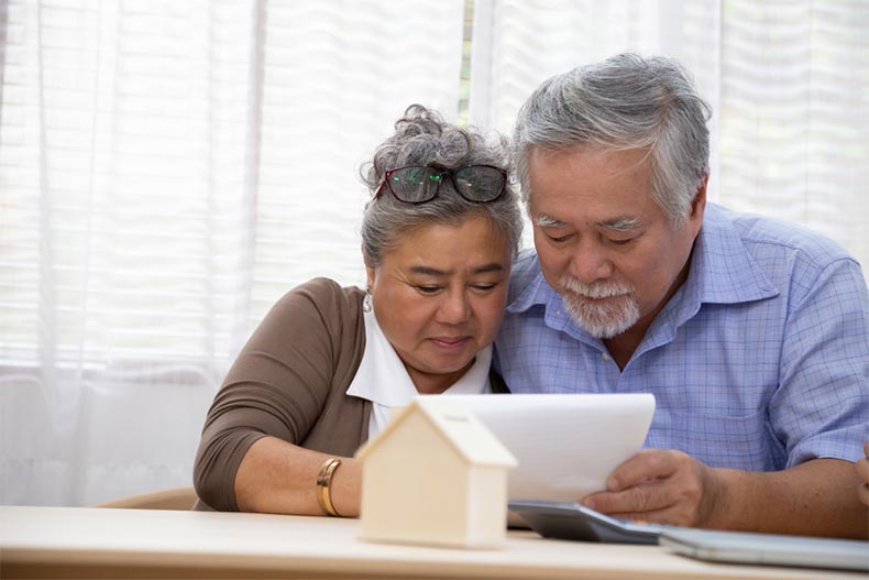 A senior couple signing a contract to buy a new house