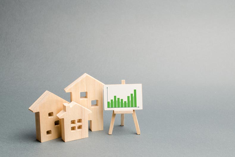 Wooden house cutouts beside a graph on an easel