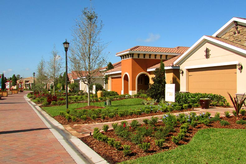 Exterior view of several model homes in Solivita lining a brick road, located in Kissimmee, Florida
