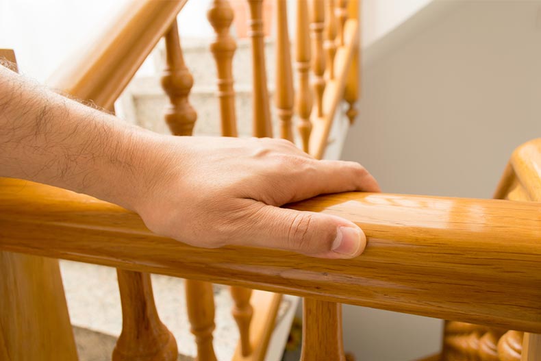 A hand on a stair railing in a home
