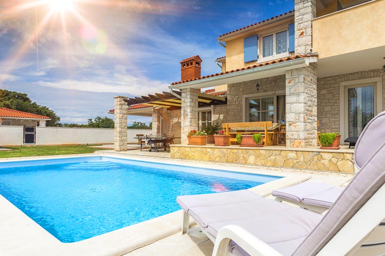 Lounge chairs beside an outdoor pool at a vacation home