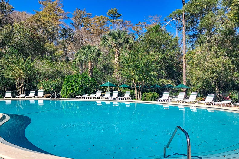 Lounge chairs on the patio surrounding the outdoor pool at Huntington at Hunter's Ridge in Ormond Beach, Florida