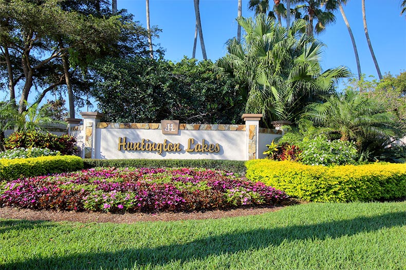 Flowers and greenery surrounding the sign for Huntington Lakes in Delray Beach, Florida
