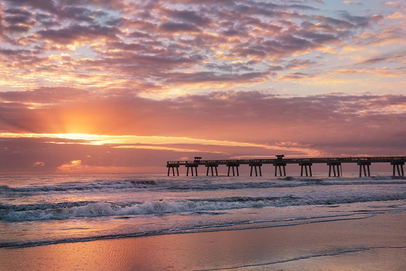 Sun rising over a beach with a pier in Jacksonville, Florida