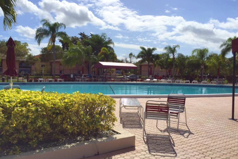 Lounge chairs on the patio beside the outdoor pool at Kings Point in Tamarac in Tamarac, Florida