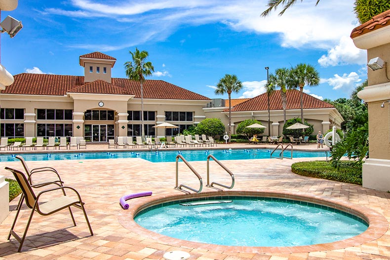 Palm trees and lounge chairs surrounding the outdoor pool and whirlpool spa at Kings Ridge in Clermont, Florida