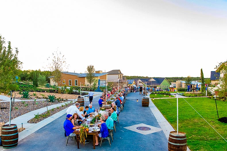 Group of homeowners enjoying dinner together during a block part in Kissing Tree, Texas