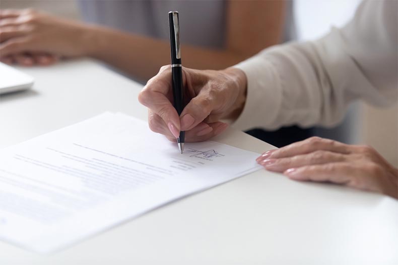Closeup of a senior woman's hand signing a contract