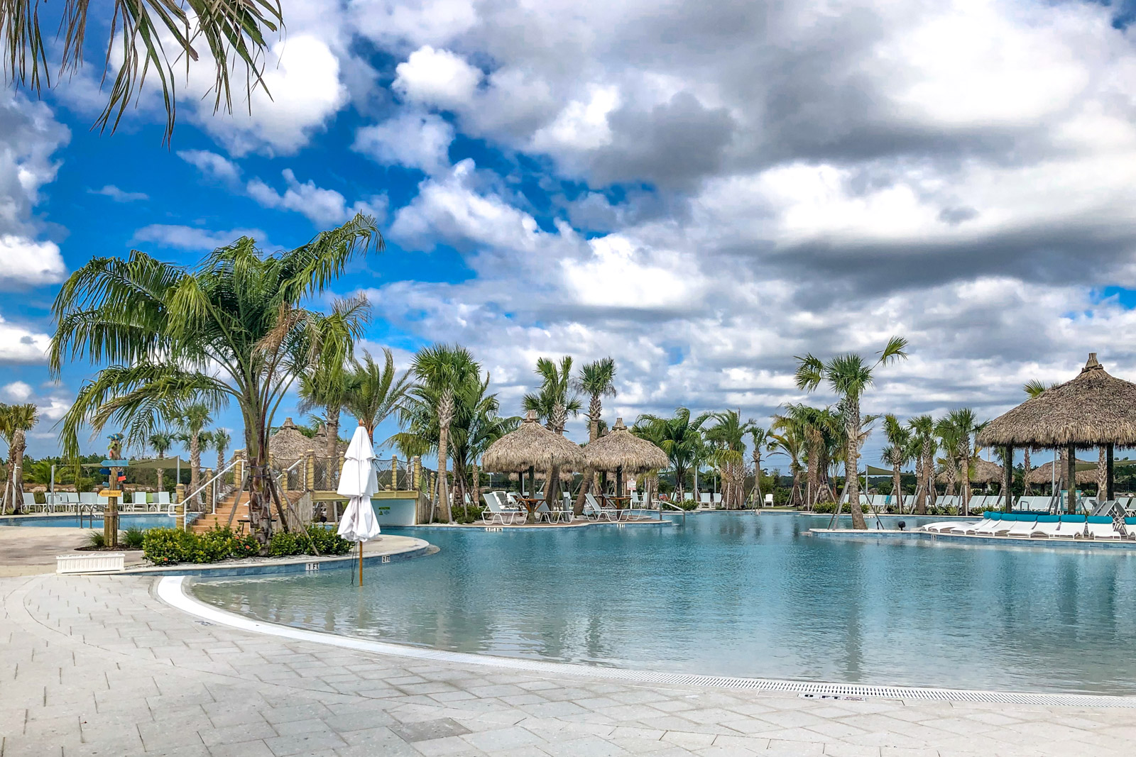 Palm trees and cabanas surrounding the resort-style outdoor pool at Latitude Margaritaville in Daytona Beach, Florida